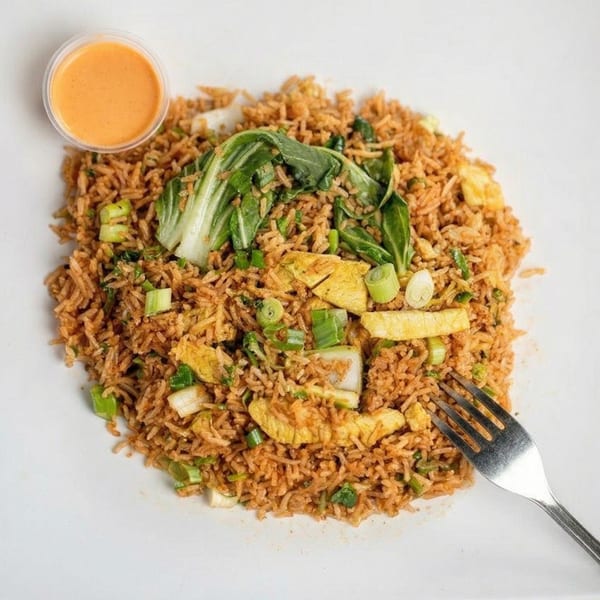 Fried rice with bok choy, scrambled egg, green onions, and a side of orange sauce.